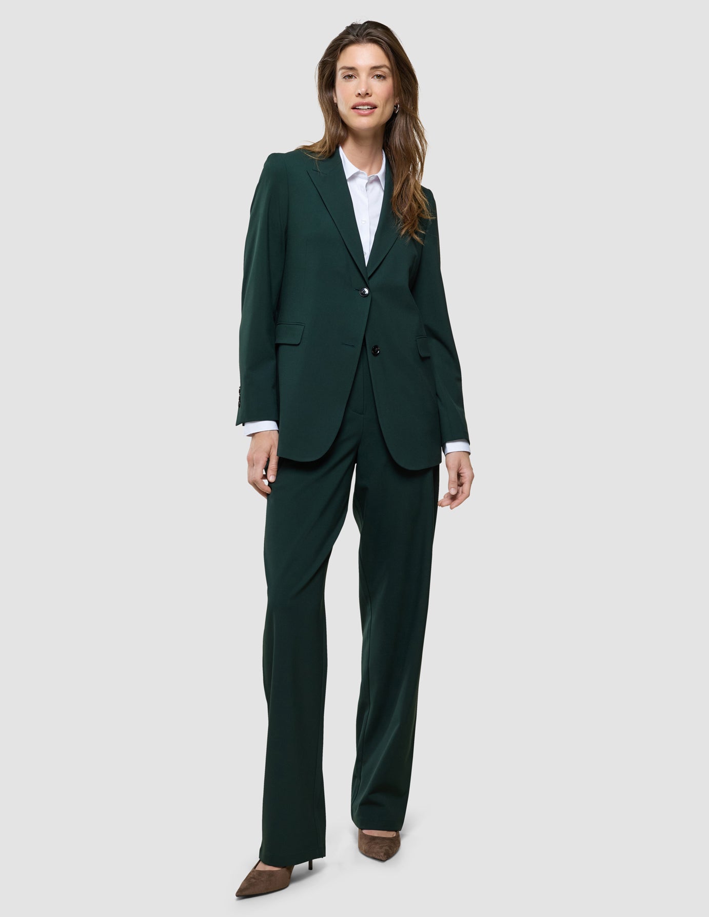 Ease Pants Wide i Evergreen, helfigur med model i mørkegrønt habitudsæt og hvid skjorte.